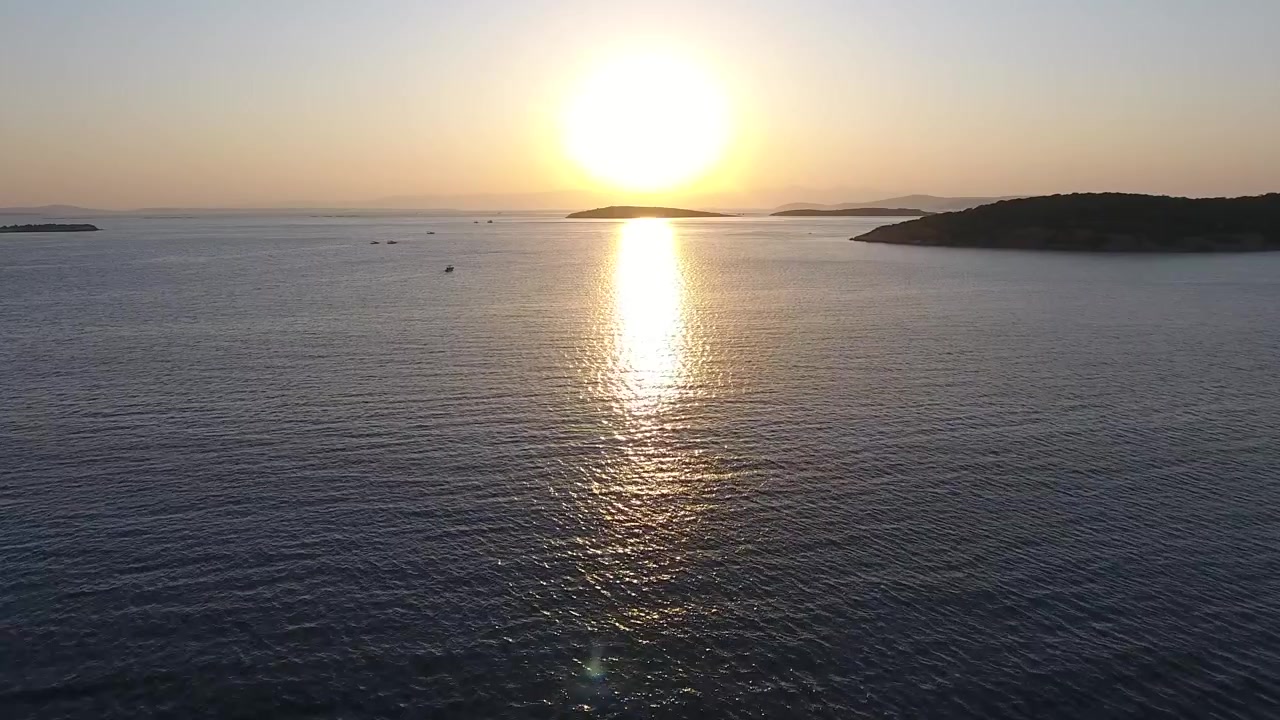 Aerial View of Golden Sunset Over Calm Sea and Distant Islands