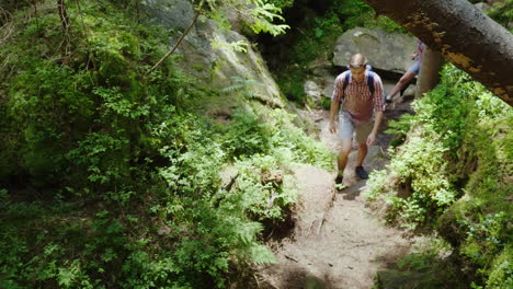 young people on a hike they walk along a narrow mountain path