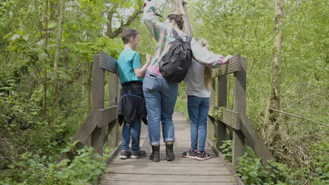 Family Hiking on a Wooden Bridge