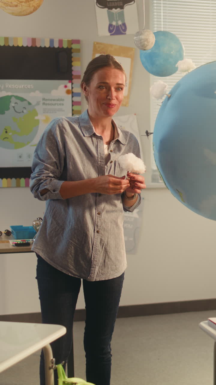 Primary School Boy Presenting Green Energy Sources in Front of Class Using Earth Model