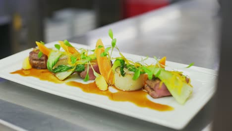 a plate of food sits on top a stainless steel counter in a restaurant