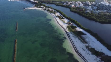 vista aérea de la playa de puerto cancún con un kitesurfista sobre las claras aguas azules del océano