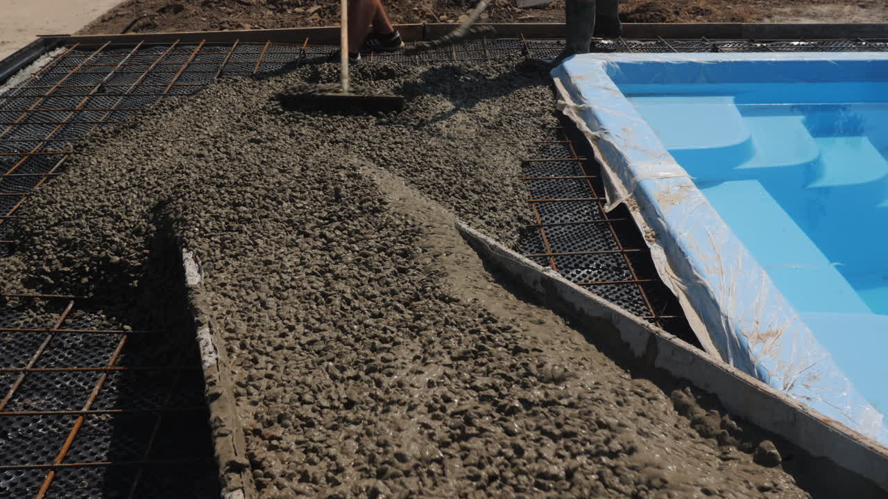 el hormigón fluye por las canaletas donde los trabajadores pavimentan 3