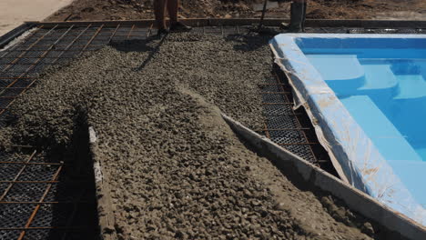 concrete flows down the gutters where workers make paving 3