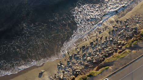 vista de los pájaros malibu panorámica a través de las olas chocando contra la orilla de pch