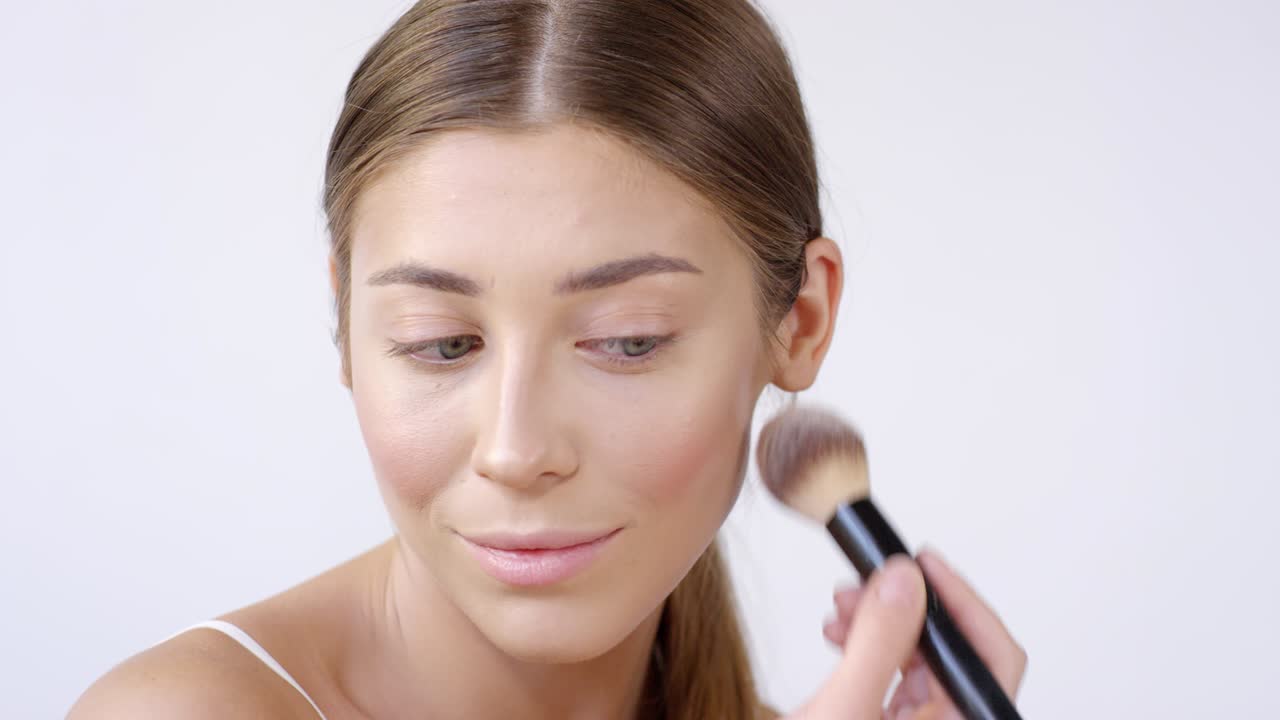 una mujer hermosa aplicando rubor.