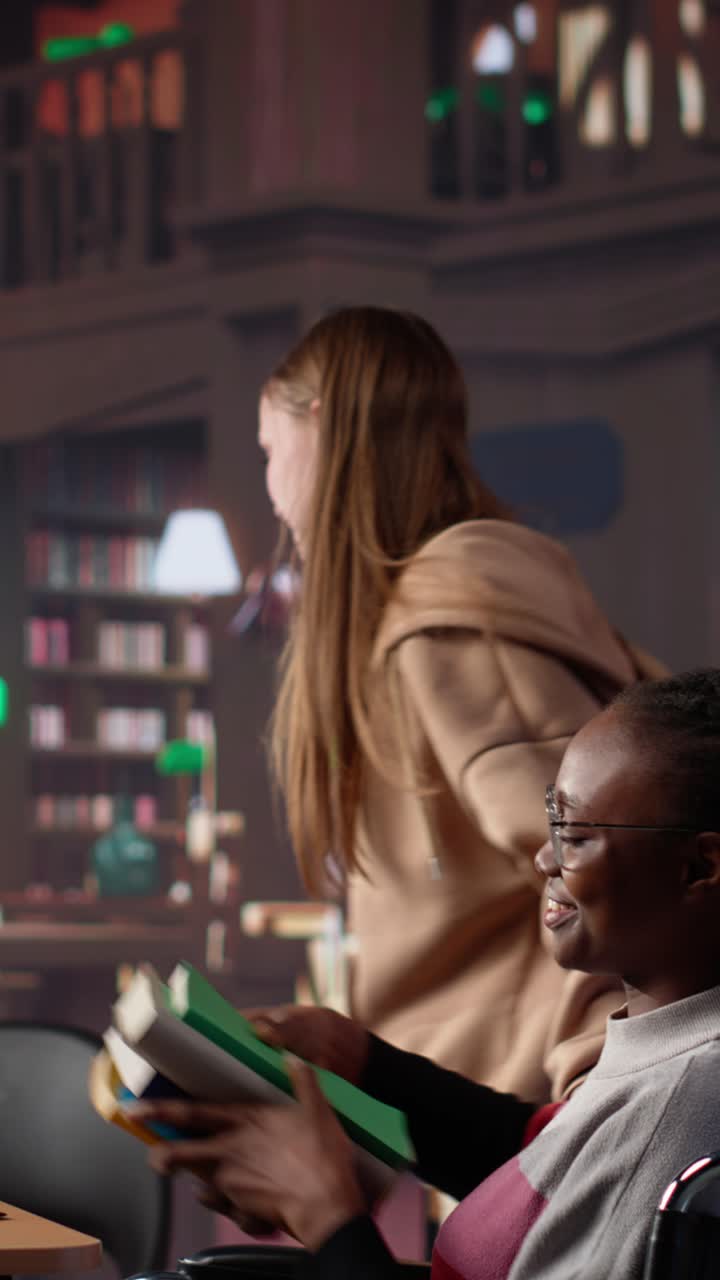 Vertical video girl pushing her colleague with physical impairment through the library