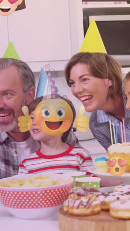 animation of emoticons over happy caucasian family during birthday party taking selfie