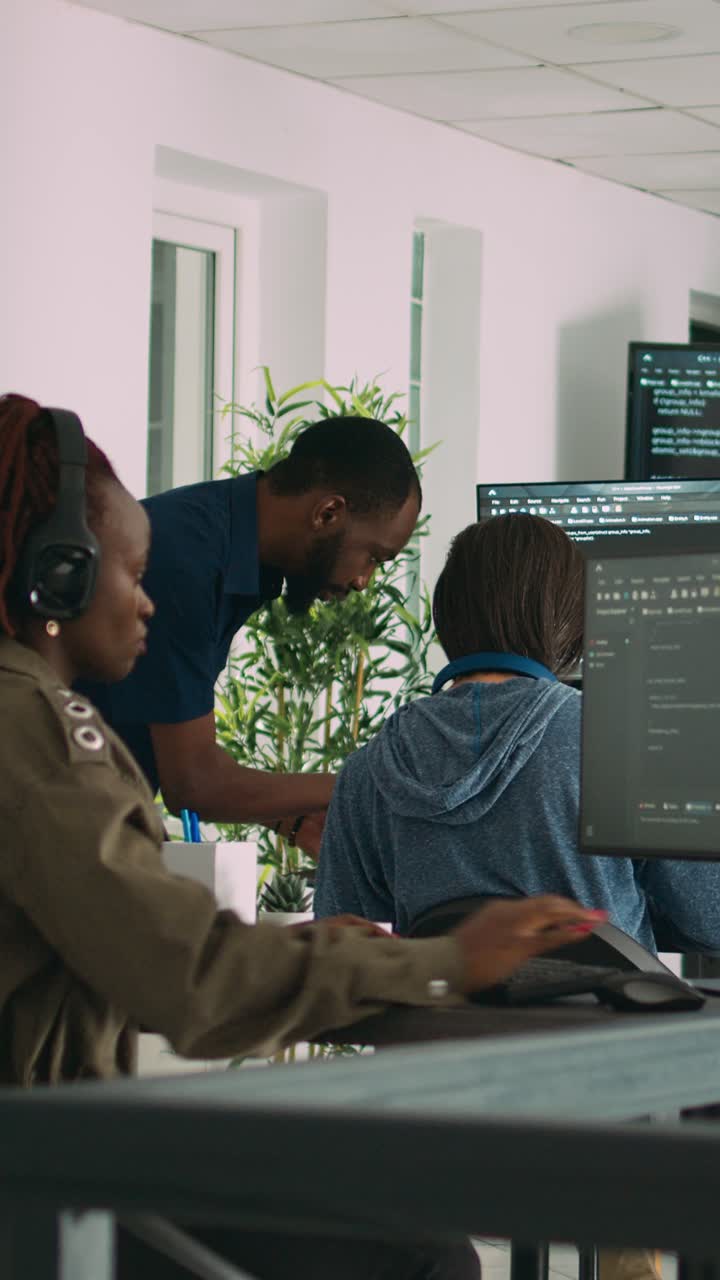 Vertical video: African american focused software engineer working on computer screen