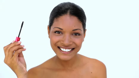 happy woman applying mascara on her eyelashes