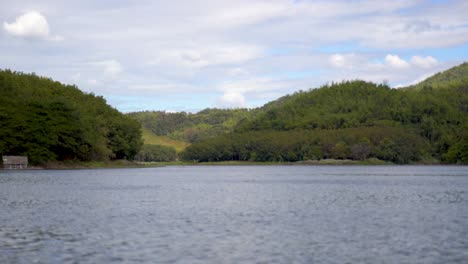 agua que fluye en un lago de río tranquilo con tierras verdes de bosques montañosos en un día soleado de verano