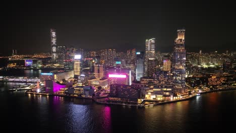 profile view of downtown skyline during nighttime shining with lights in hong kong.
