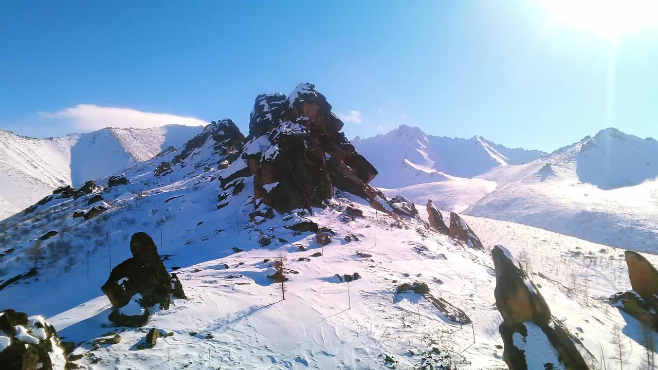 눈 인 산 들 과 빛 이 있는 파란 하늘 을 배경 으로 한 겨울의 바위 들 의 아름다운 새 눈 으로 볼 수 있다