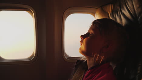 un vuelo difícil para una niña pequeña un niño dormido en el fondo del sol naciente en el aire