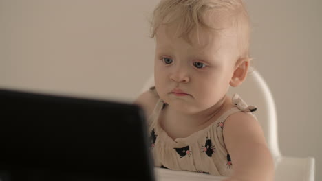 Little-girl-watching-cartoons-on-tablet-computer-at-home