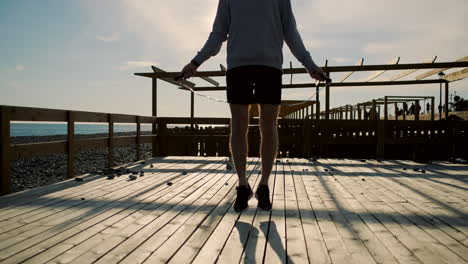 Man Jumping Rope on a Beach Pier at Sunset