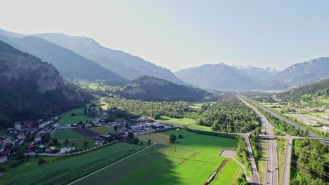Aerial-View-Of-Rothenbrunnen-Municipality-In-Swiss-Canton-of-Graubünden-With-Morning-Sunlight-Across-Valley-Floor