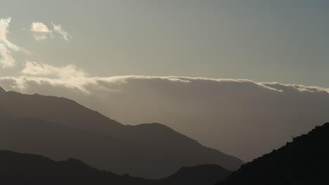 Zeitraffer-Des-Sonnenuntergangs-Hinter-Wolken-Und-Bergen