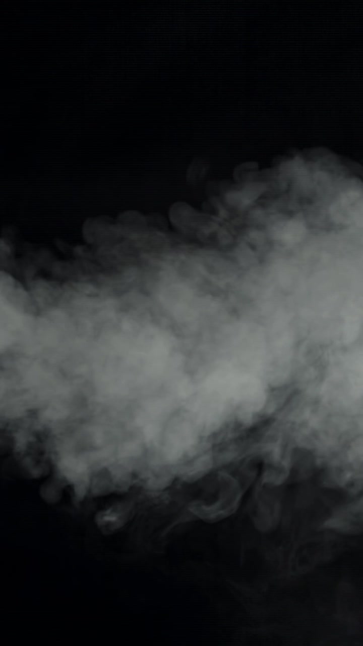 Fumo bianco denso che scorre su uno sfondo nero