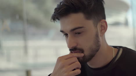 Handsome-bearded-man-working-in-outdoor-cafe