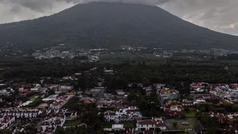 Luftaufnahme,-Drohnen-Hyperlapse,-Der-An-Einem-Bewölkten-Tag-In-4K-Auf-Einen-Vulkan-Neben-Einer-Stadt-In-Guatemala-Zufliegt