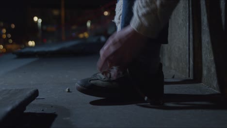 Tying-shoelace-on-the-street-at-night