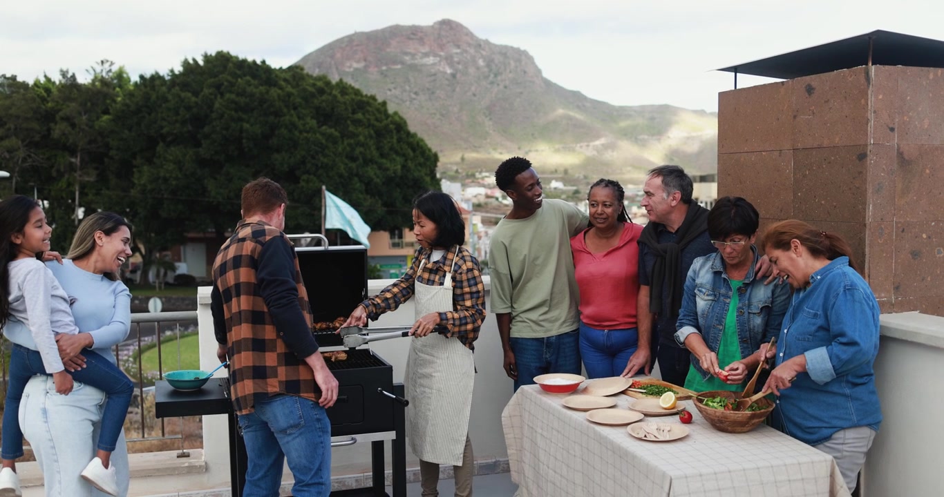 Happy Multi-Generational and Multi-Ethnic Group Enjoying a Rooftop BBQ Party