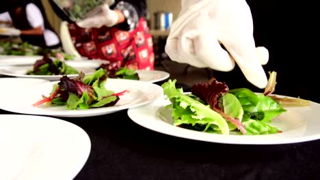 hands putting leaves for salad at a banquet