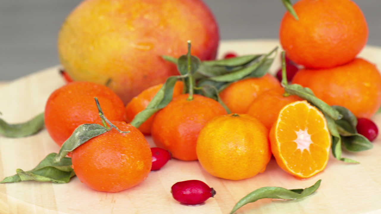 Composition with oranges, mango, rosehip and green leaves