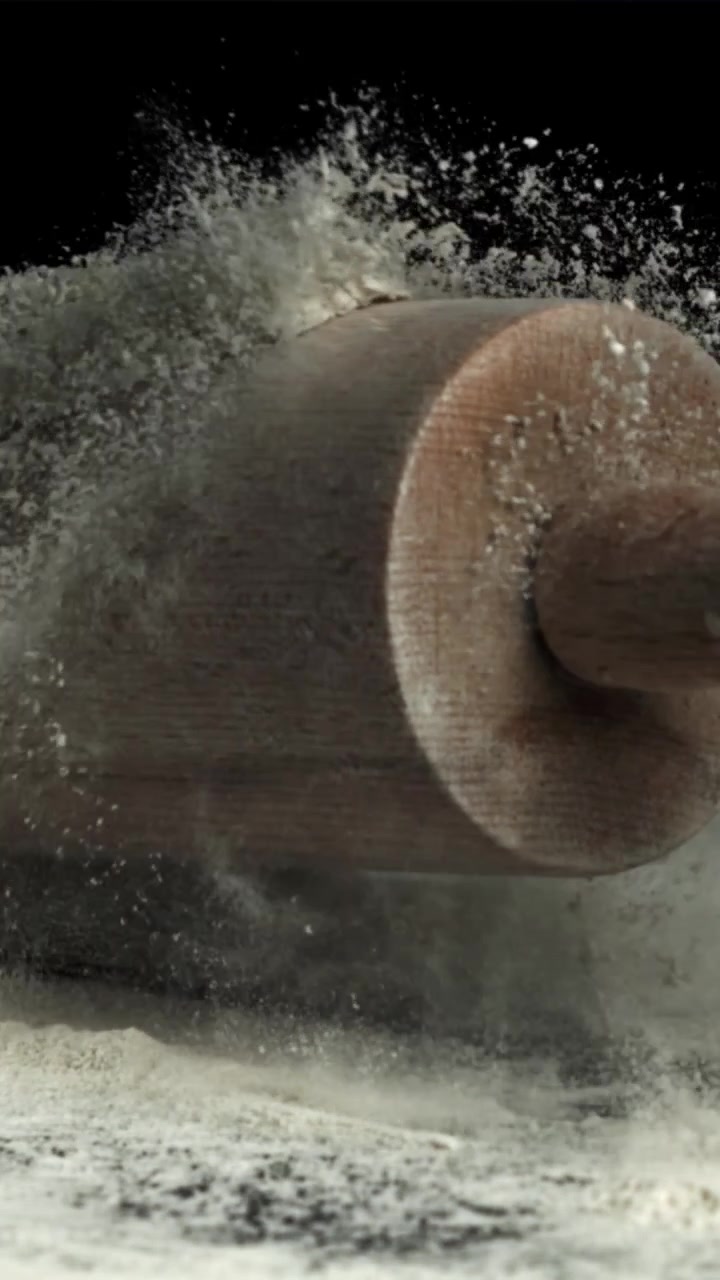 Mattarello di legno che cade sulla farina al rallentatore.
