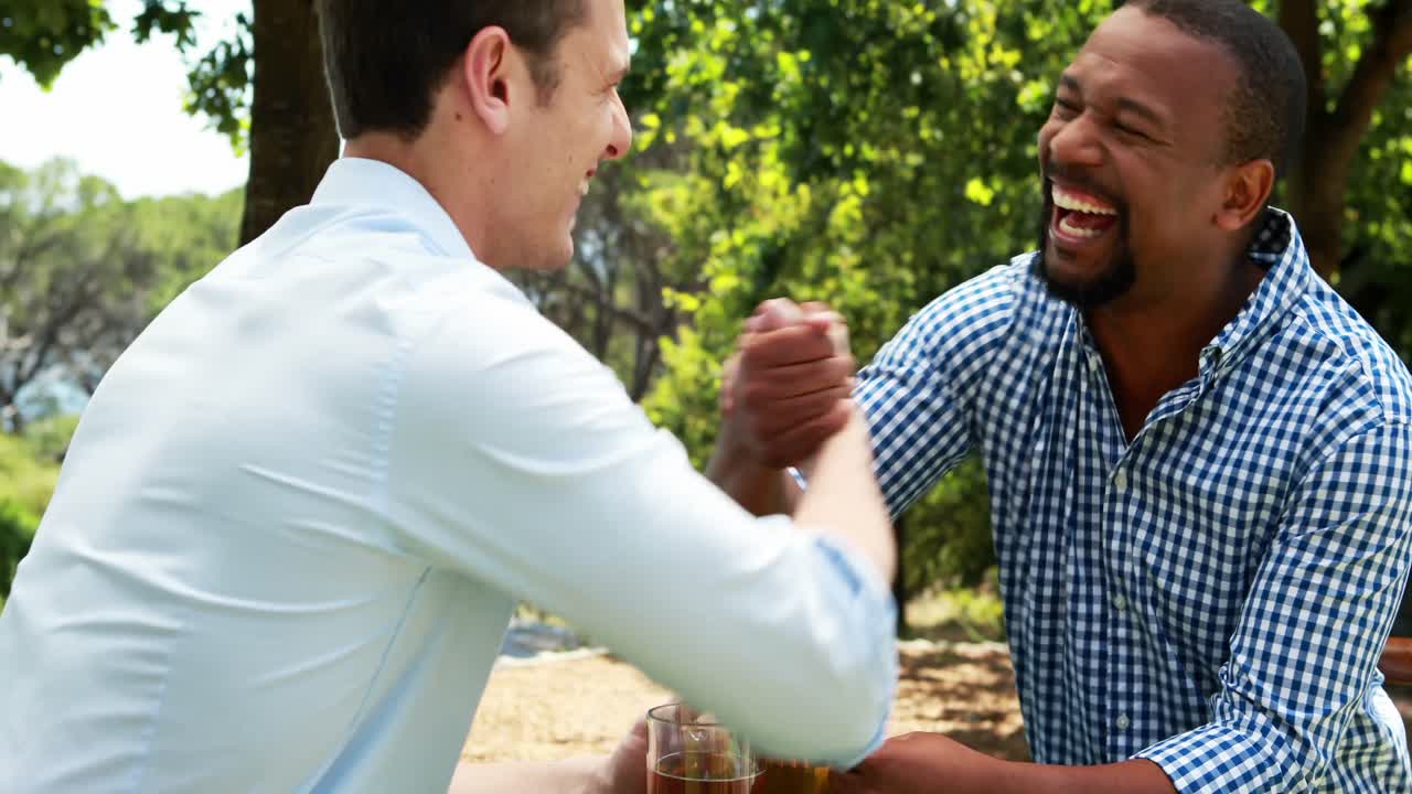 Male friends toasting beer mugs in outdoor restaurant 4k