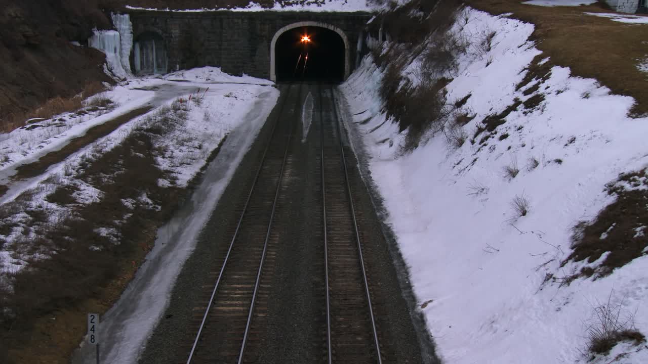 ángulo alto sobre un tren de pasajeros que atraviesa un túnel en invierno