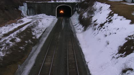 high angle over a passenger train going through a tunnel in the winter