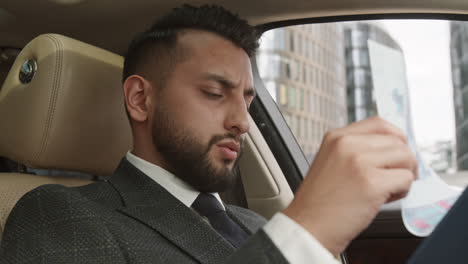 businessman looking through papers in auto