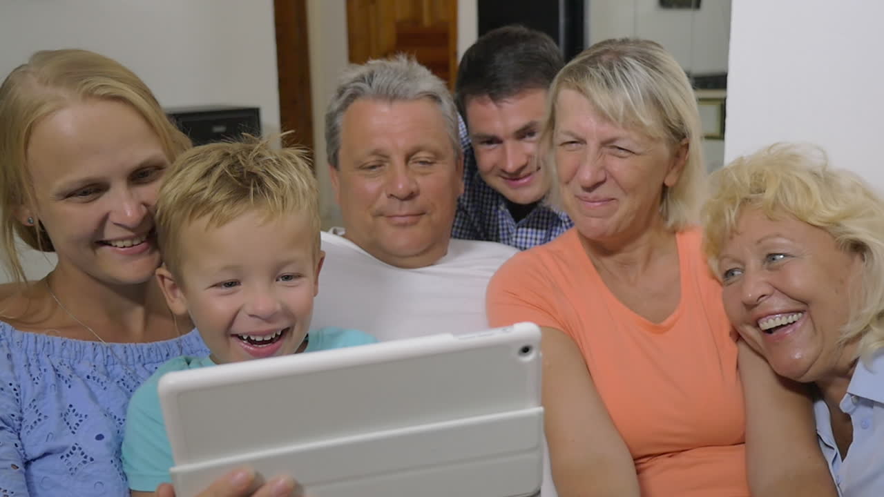 famiglia con il bambino che guarda un video interessante sul pad