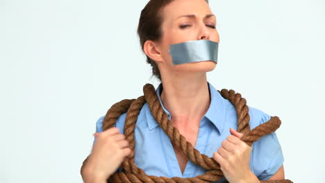 businesswoman attached with a rope and having tape on her mouth