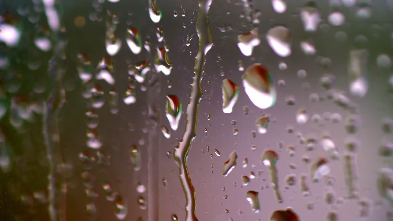 gotas de lluvia en la ventana. gotas de agua que caen en la superficie del vidrio. gotes de agua que cayen. video de enfoque selectivo.