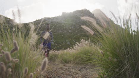 Diverse-couple-exercising-running-across-a-field-in-the-countryside