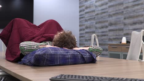useless employee taking a nap on the conference table at work.