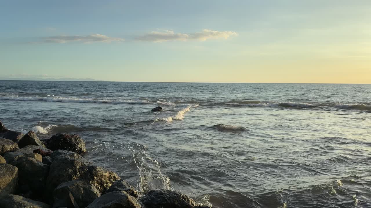 Sanfte Meereswellen am Felsstrand bei Sonnenuntergang