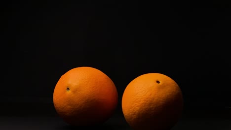 rolling orange fruit, black background