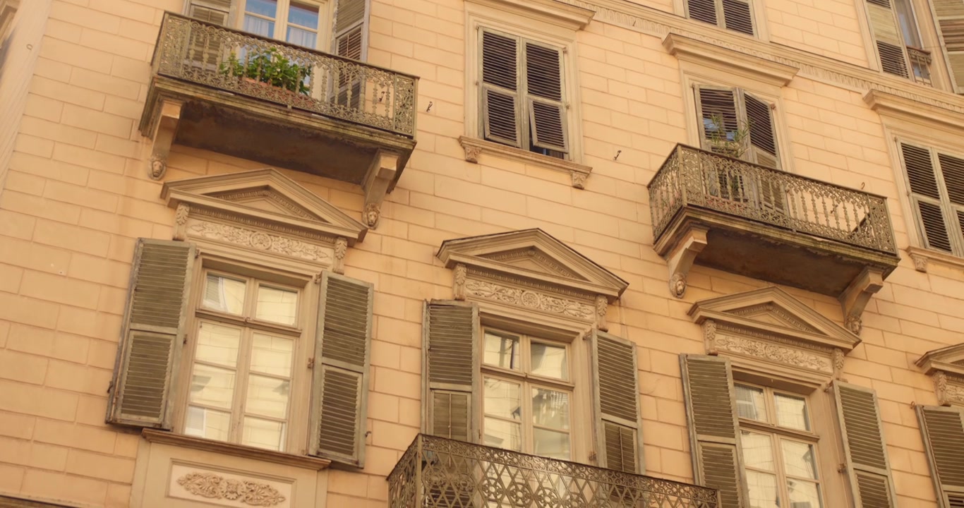 Fachada de Edifício Residencial Clássico Estilo Europeu Com Janelas Tradicionais com Persianas e Varandas Ornamentadas de Ferro Forjado em Turim, Itália. Tomada de Ângulo Baixo