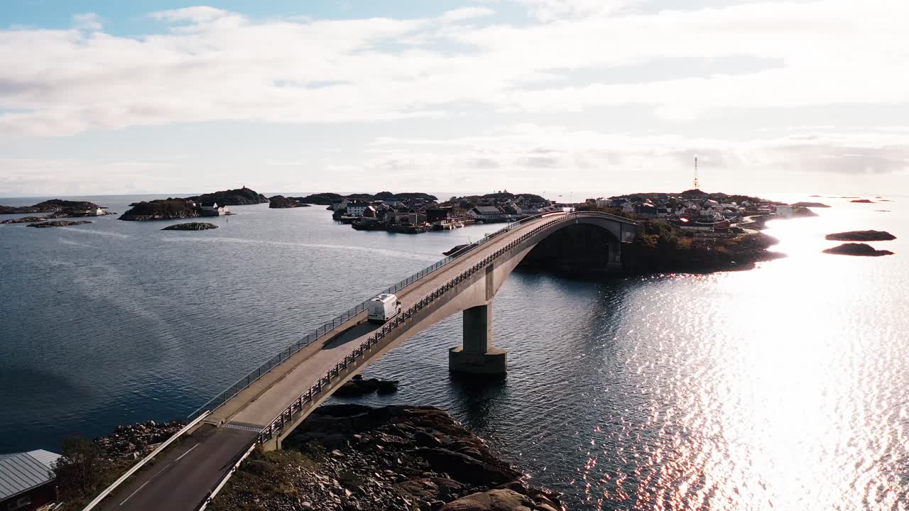 Vista aerea di un camper bianco che arriva a Henningsvær attraversando un ponte nelle Isole Lofoten, Norvegia