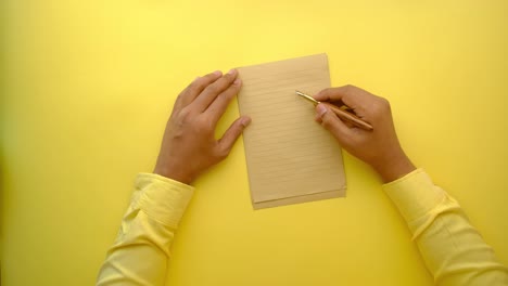 person writing on lined paper with a fountain pen