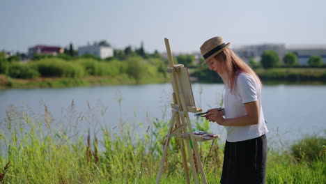 woman painting outdoors by a lake