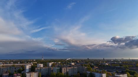a scenic sunset view over apartment buildings and the riga tv tower in the purvciems neighborhood of riga, latvia - aerial pullback shot