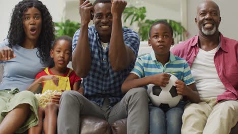 Happy-african-american-family-cheering-while-watching-match-in-tv