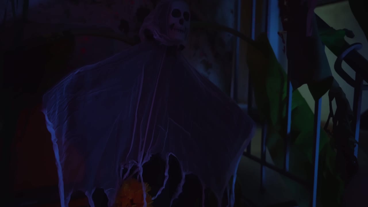 habitación decorada para la fiesta de halloween: primer plano de un esqueleto aterrador colgado en una pared en la habitación oscura y fría