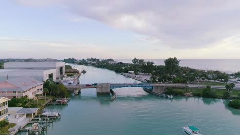 Luftschwenkaufnahme-Eines-Bootes,-Das-Durch-Die-Bucht-Am-Strand-Von-Nokomis-Fährt-Und-Sich-Der-Zugbrücke-Nähert