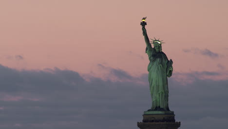 statue of liberty on pedestal at sunset, pink sky